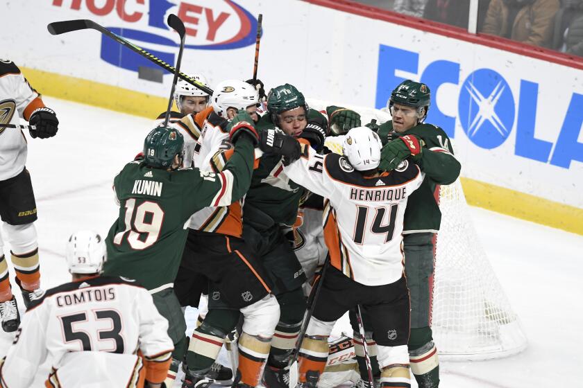 Minnesota Wild's Jordan Greenway, center, is surrounded by Wild teammates and Anaheim Duck players after getting off a shot on the Ducks' goal in the first period of an NHL hockey game, Tuesday, Dec. 10, 2019, in St. Paul, Minn. (AP Photo/Tom Olmscheid)