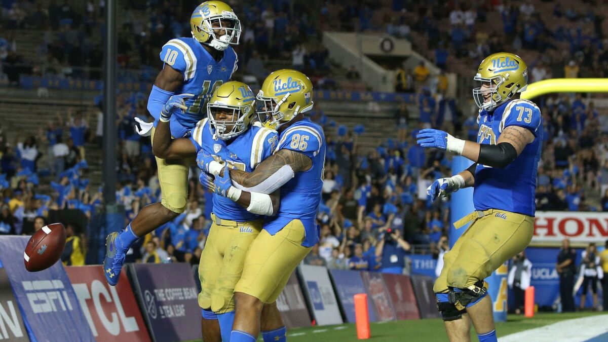 UCLA's Demetric Felton (10), Joshua Kelley (27), Devin Asiasi (86) and Jake Burton (73) celebrate Kelley's rushing touchdown during the second half against Arizona at the Rose Bowl on Saturday.