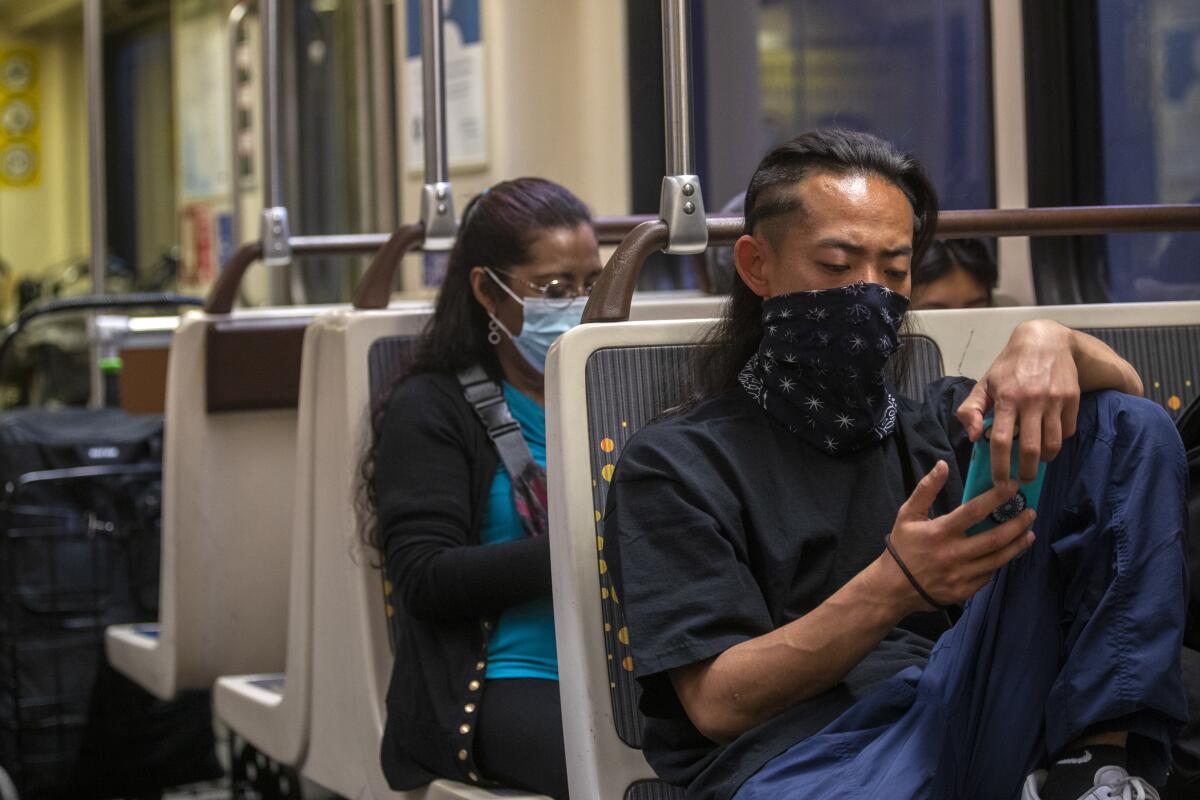 Metro rail riders wear masks. 