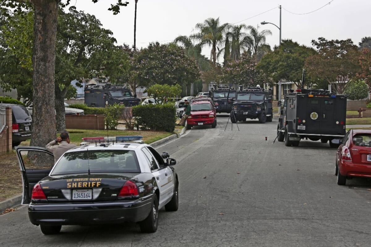 Los Angeles County sheriff's armored vehicles in front of a home early Saturday in Pico Rivera where a gunman and a hostage were killed during a shootout with authorities.
