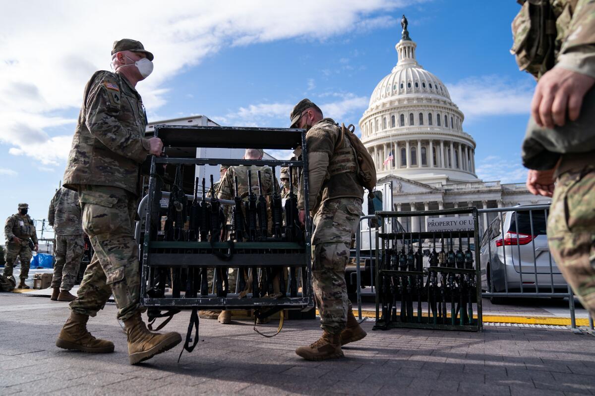 National Guard members unload weapons and supplies outside of the U.S. Capitol building.