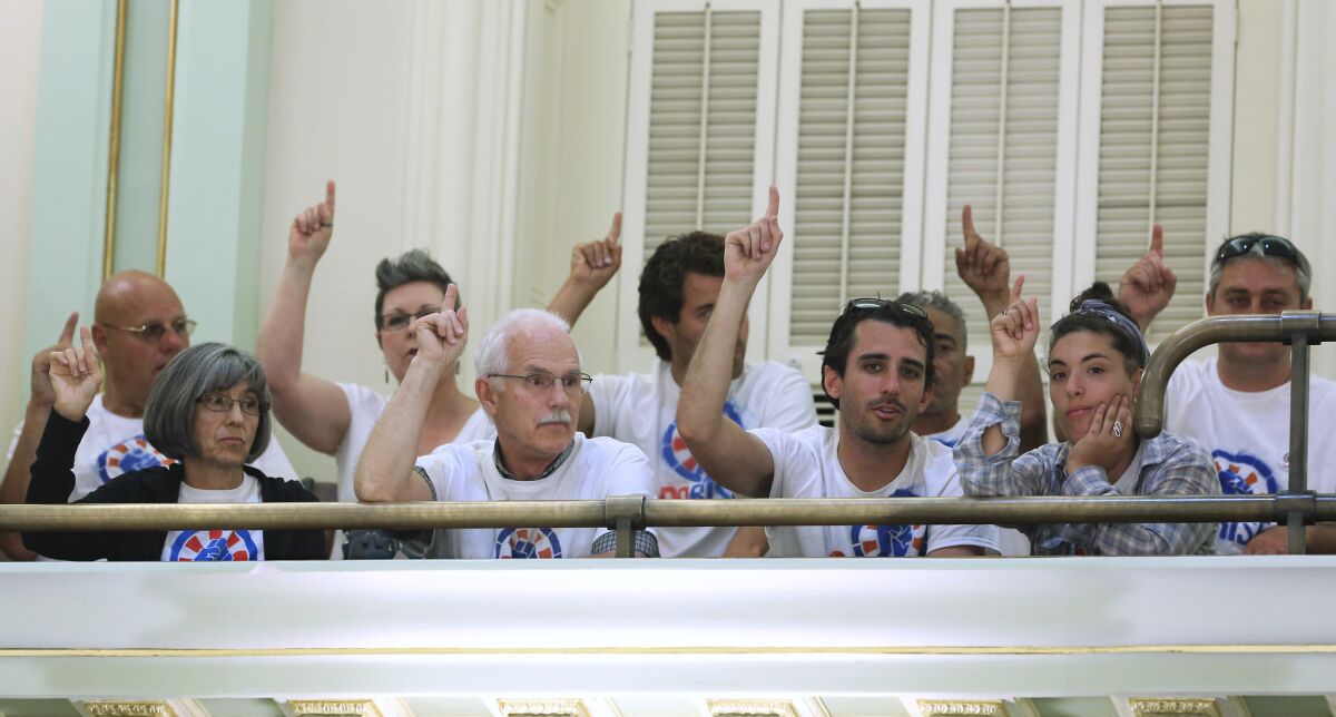 Activists gather in the Assembly chambers in June 2014 to show their support for a bill placing a nonbinding advisory measure about Citizens United on the ballot. (Rich Pedroncelli / Associated Press)