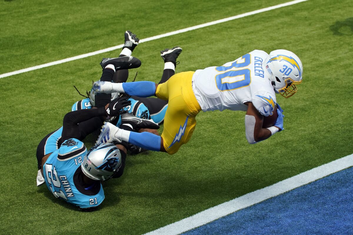 Los Angeles Chargers running back Austin Ekeler (30) lunges into the end zone for a touchdown over Carolina Panthers outside linebacker Jeremy Chinn (21) during the first half of an NFL football game Sunday, Sept. 27, 2020, in Inglewood, Calif. (AP Photo/Ashley Landis )
