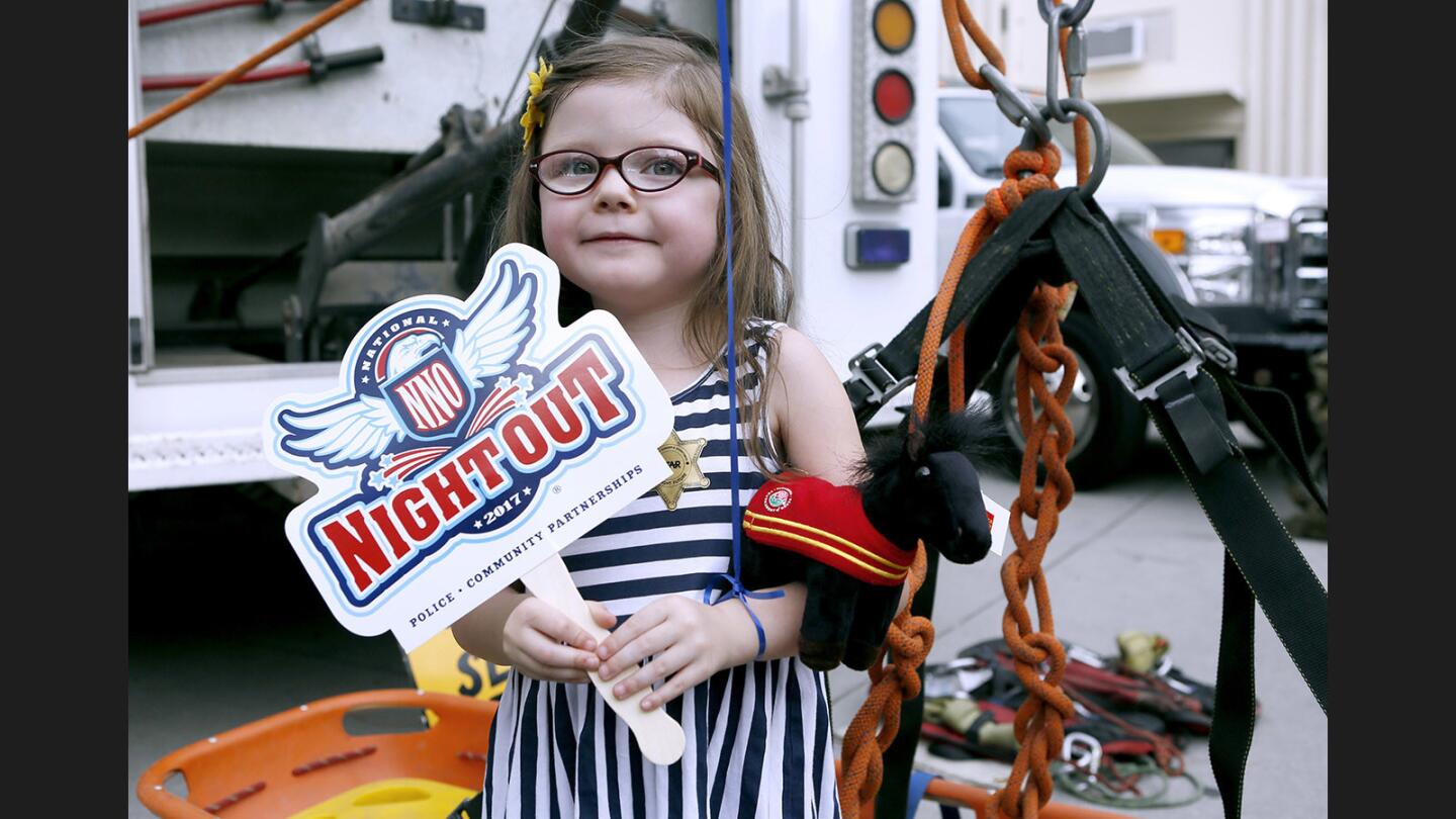 Rosie Hahn, 5 of La Crescenta, strikes a pose next to the Montrose Mountain Search and Rescue equipment while holding her National Night Out 2017 fan, at the Crescenta Valley Sheriff's Station event in La Crescenta on Tuesday, August 1, 2017.