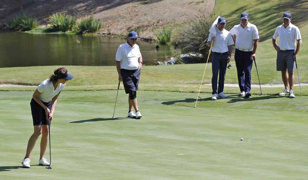 Members of the Santa Ana Country Club golf team watch as teammate Diane Booth putts on Thursday.