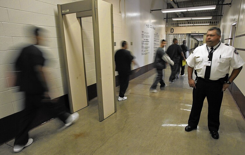 Inmates from California pass through a metal detector at the Florence Correctional Center, a prison operated by Corrections Corporation of America in Florence, Ariz., in 2007