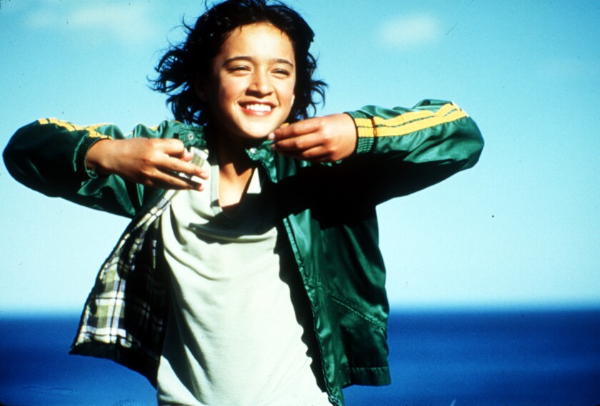 Keisha Castle–Hughes in “Whale Rider” raises her arms and looks excited.