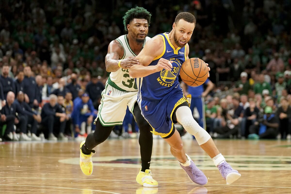 Golden State Warriors guard Stephen Curry drives against Boston Celtics guard Marcus Smart.