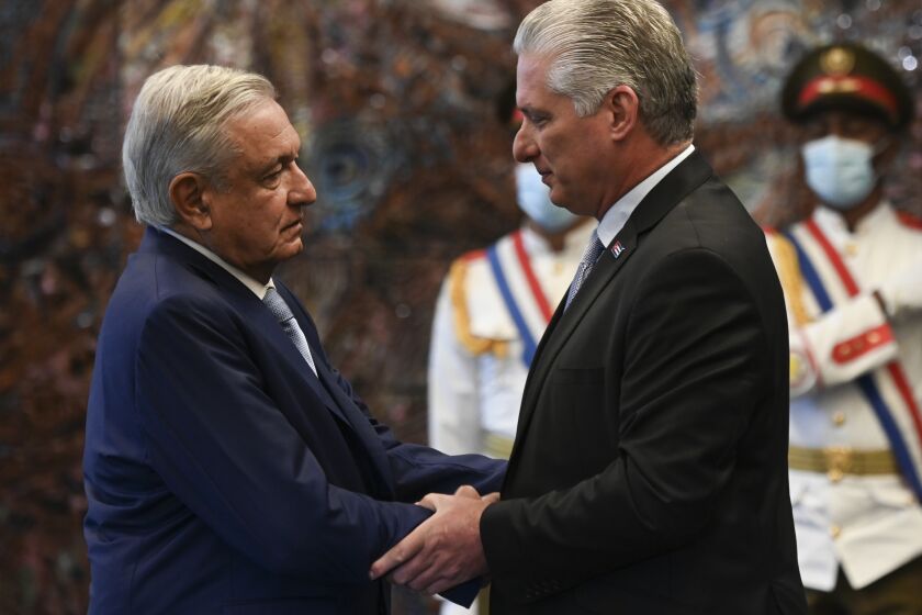 Cuban president Miguel Diaz Canel, right, shakes hands with his Mexican counterpart Andres Manuel Lopez Obrador at Revolution Palace in Havana, Cuba, Sunday, May 8, 2022. (Yamil Lage/Pool Photo via AP)