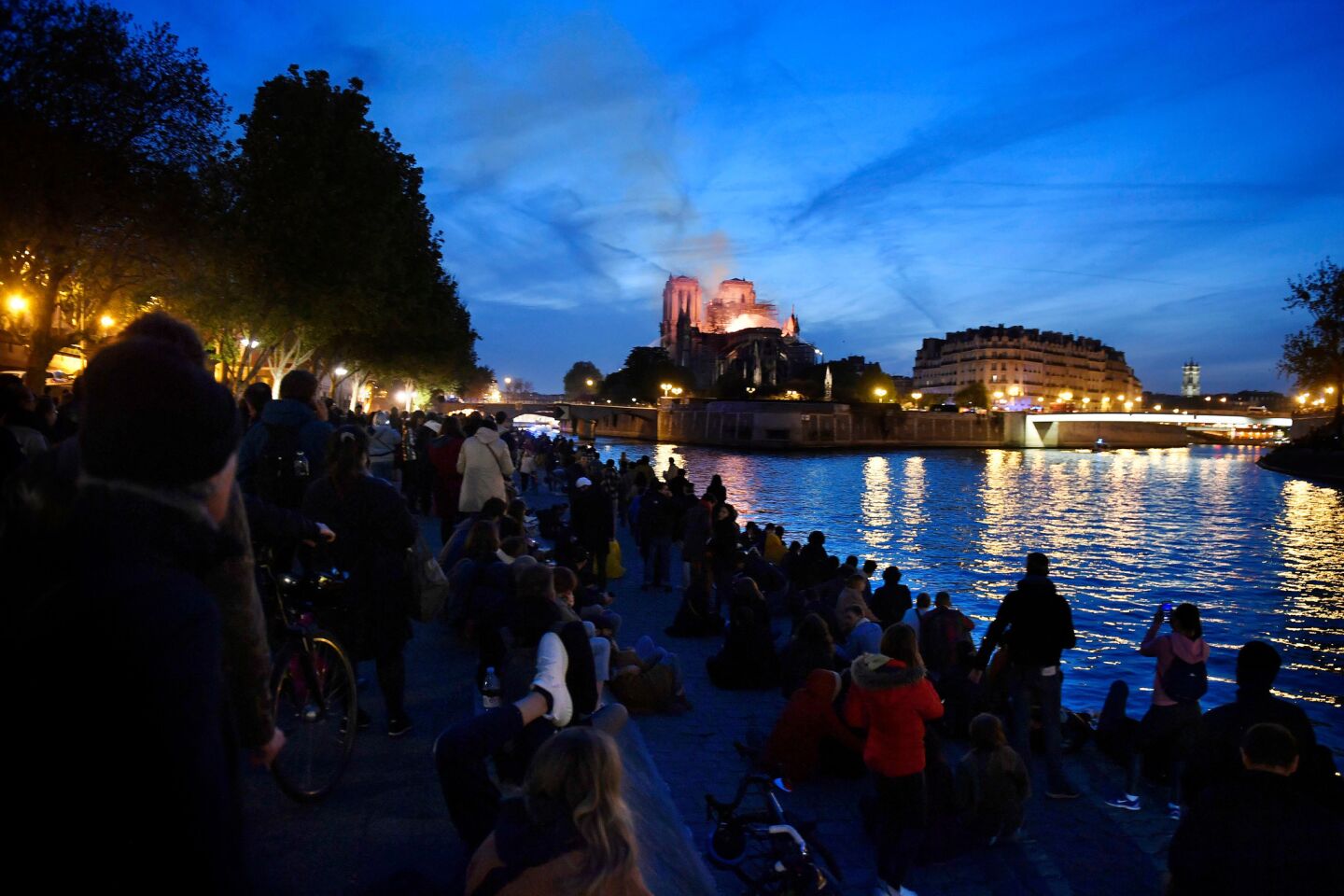 Parisians gather on the Seine riverbank to look at the flames burning the roof of Notre Dame. A ferocious and fast-moving blaze, which broke out about 6:45 p.m., destroyed large parts of the 850-year-old Gothic monument in Paris.