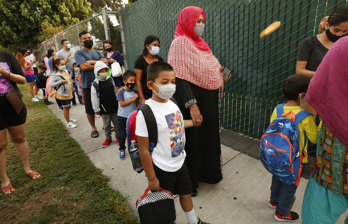 First-grader Ahnaf Abrar waits with his mother Shamima Abrar to check in at Lankershim Elementary School in North Hollywood.