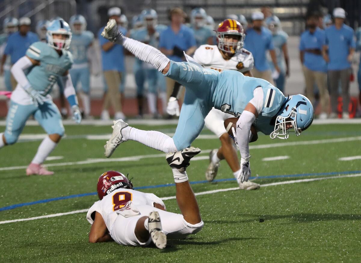 Estancia's Jorge Castor Cortinas (8) trips up University's Carl Oldham for an open-field tackle on Thursday.