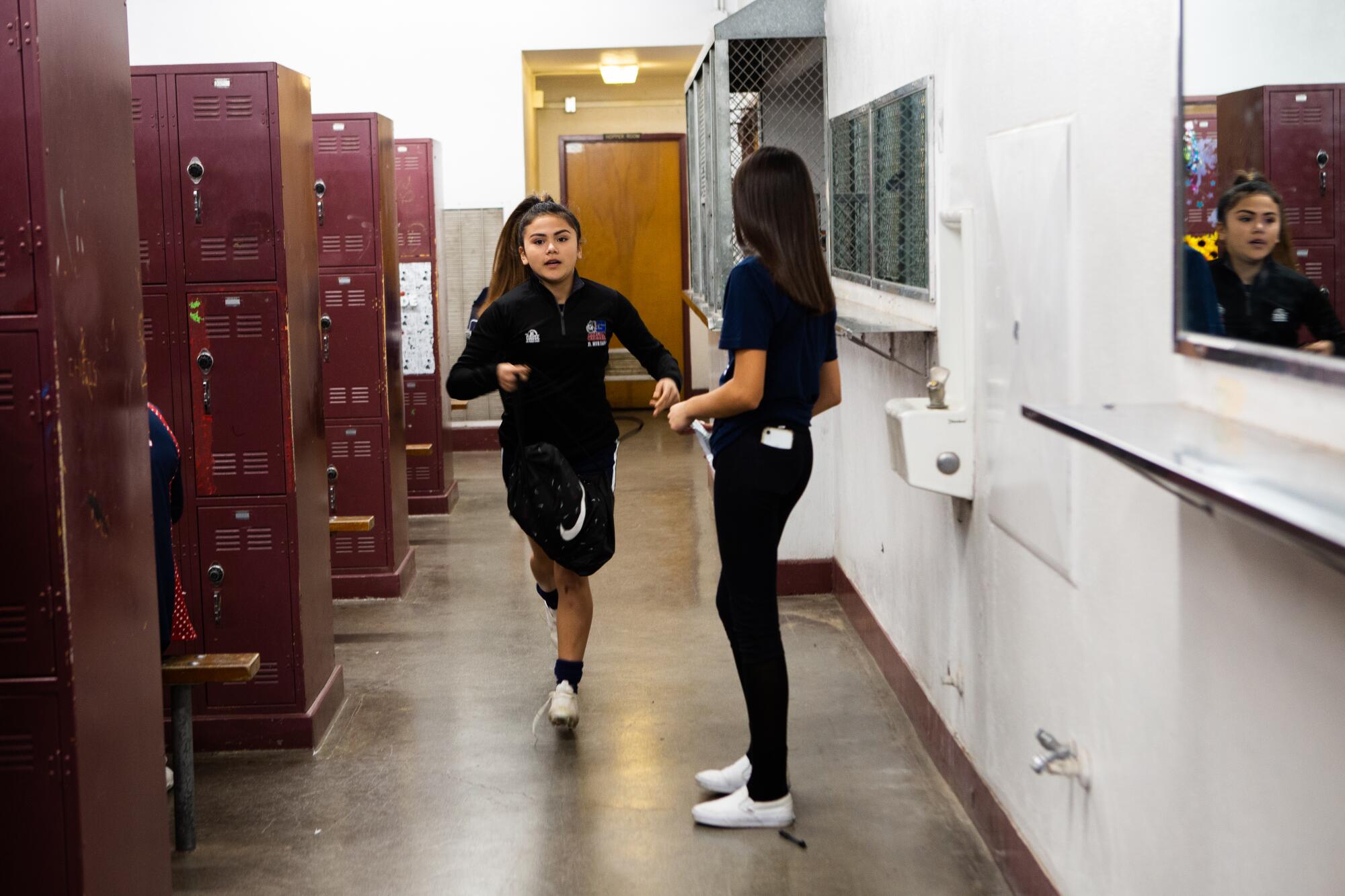 Dalia Hurtado rushes to grab something from her locker