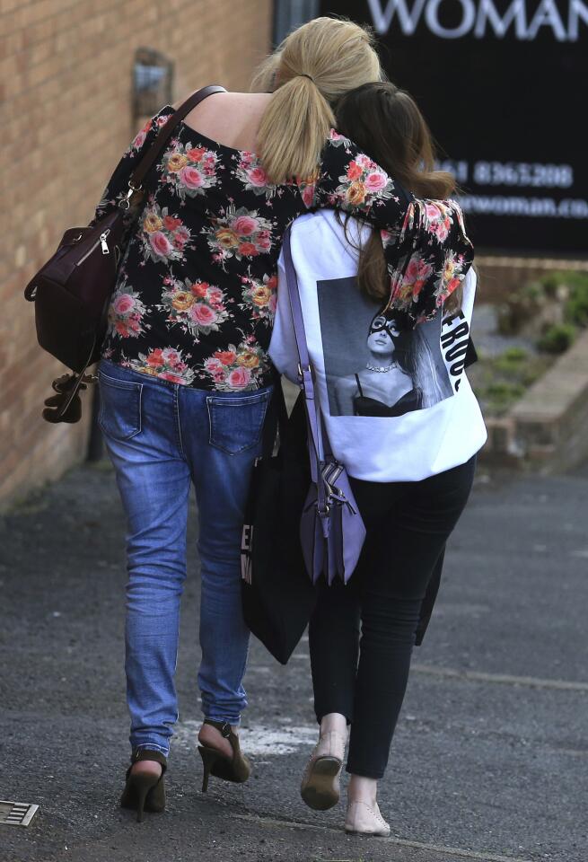 A fan is comforted as she leaves a hotel in Manchester, England, on May 23, 2017, the day after an apparent suicide bomber attacked an Ariana Grande concert, killing 22 people.