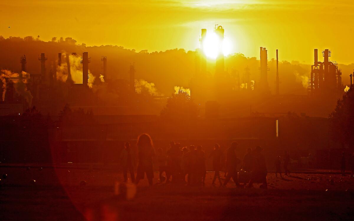 Youth soccer teams practice at Wilmington Waterfront Park in Los Angeles in the shadow of an oil refinery.