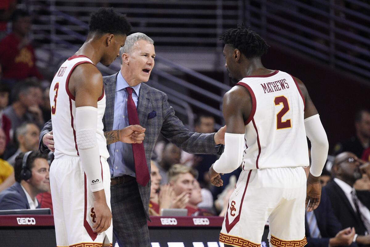 USC coach Andy Enfield talks with Jonah Mathews and Elijah Weaver during a game against Stanford in January.