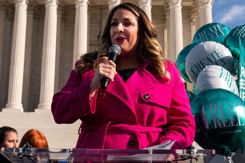   Lorie Smith, a Christian graphic artist in Colorado, speaks to supporters outside the Supreme Court in December 2022.
