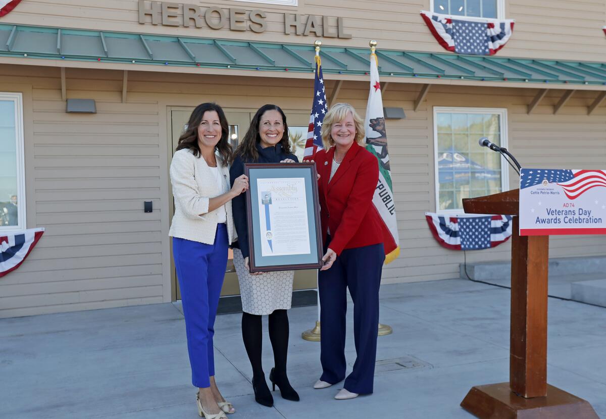 Honoree Andrea Marr (Navy), center, a Costa Mesa City Council member, is recognized Friday by state Assemblywoman Cottie Petrie-Norris, left, and Costa Mesa Mayor Katrina Foley during a ceremony at the Heroes Hall veterans museum in Costa Mesa.