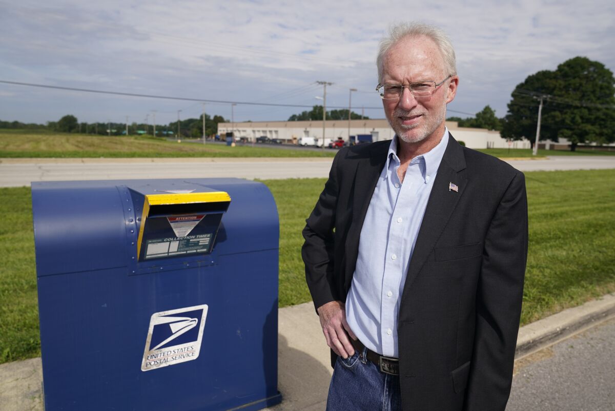 Doug Brown, postal staffer and president of the American Postal Workers Union chapter in Indiana, poses for a picture outside of a post office facility, Monday, Aug. 17, 2020, in Muncie, Ind. The U.S. Postal Service is expected to play a central role in this year's presidential elections with so many states promoting voting by mail amid the coronavirus pandemic. (AP Photo/Darron Cummings)
