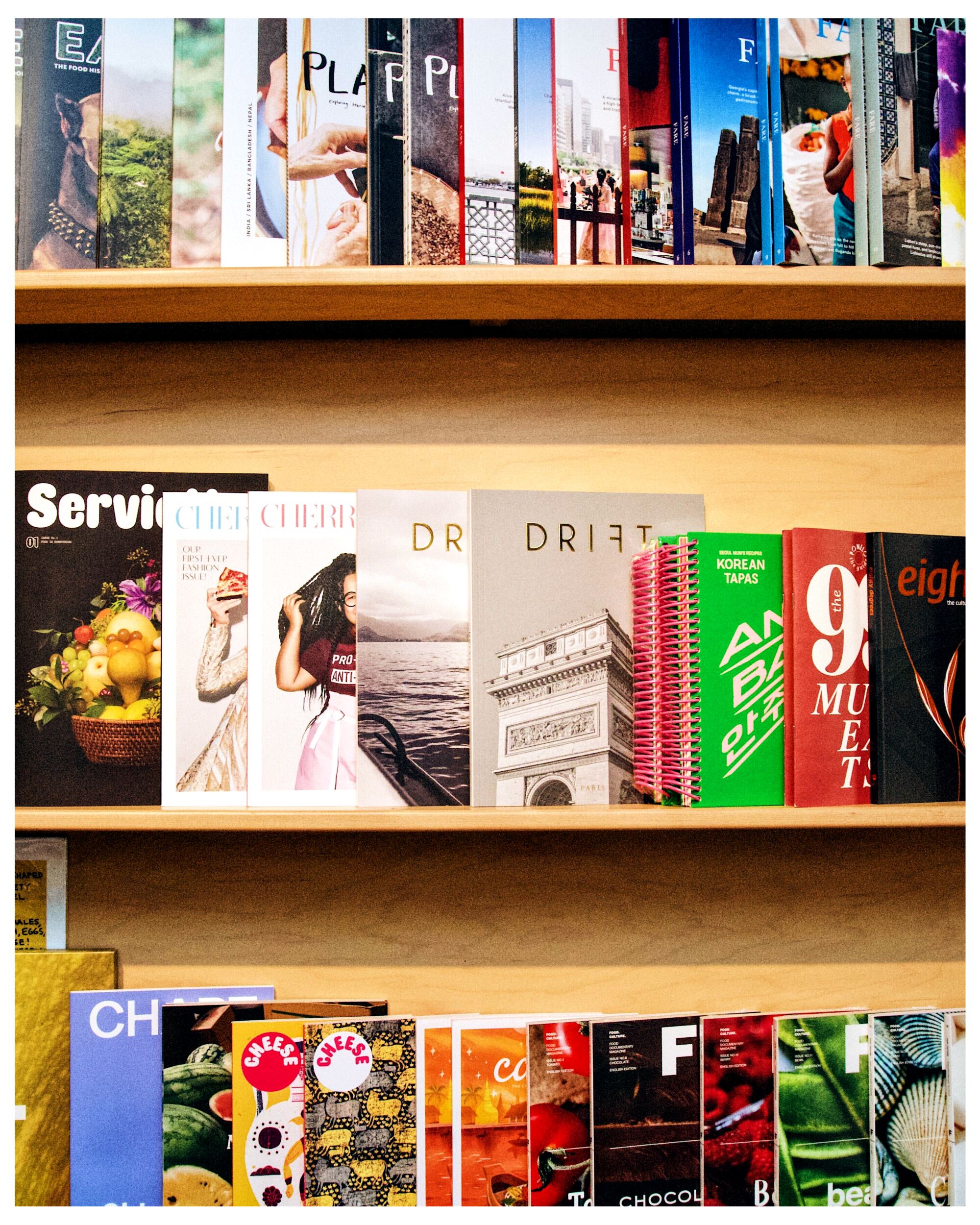 Rows of food magazines on wooden shelves in Now Serving