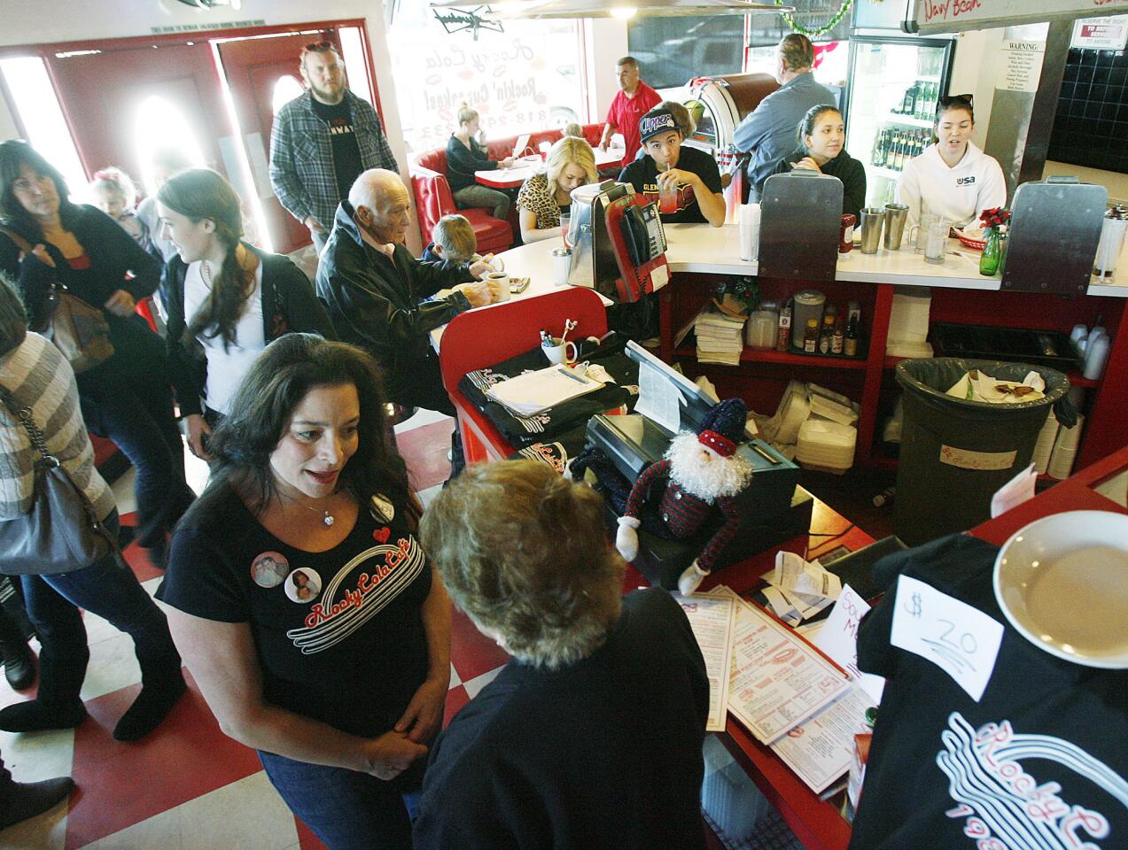 Lucy DiMino, at bottom, talks with a well-wisher at a very busy Rocky Cola Cafe in Montrose on Thursday, December 27, 2012. The diner, which has been open nearly 25 years, will close Sunday due to a downturn in the economy and an increasing number of local restaurants.