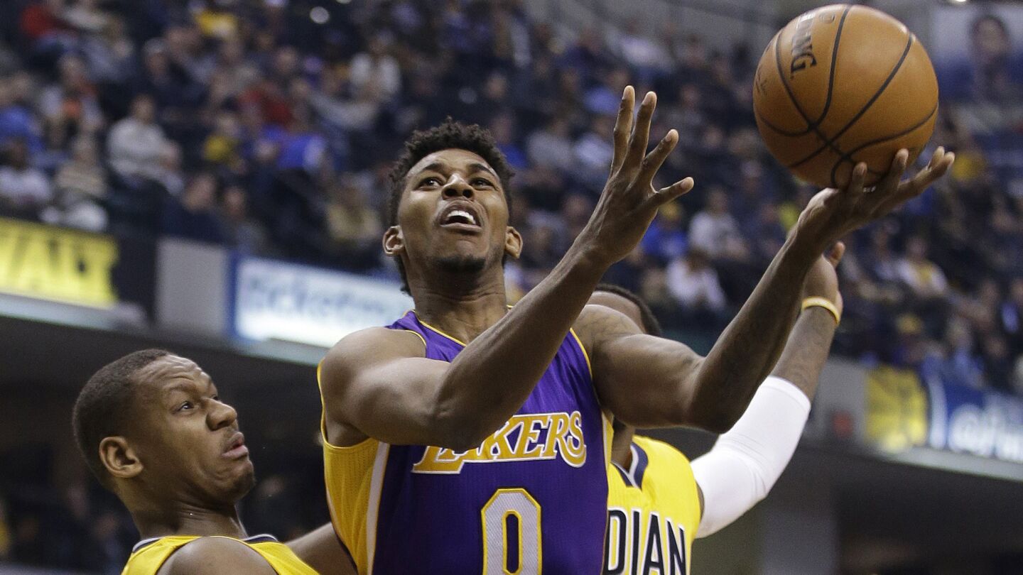 Lakers small forward Nick Young, right, puts up a shot over Indiana Pacers forward Lavoy Allen during the first half of Monday's game.