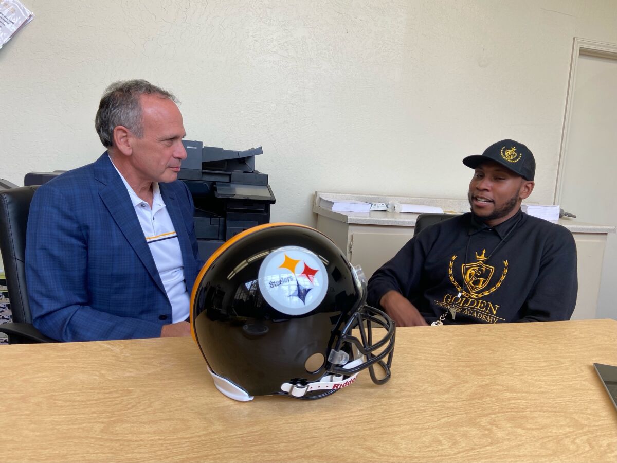 Robert Golden, right, speaks with Larry Paul, Pittsburgh Steelers minority owner, at the Golden Charter Academy.
