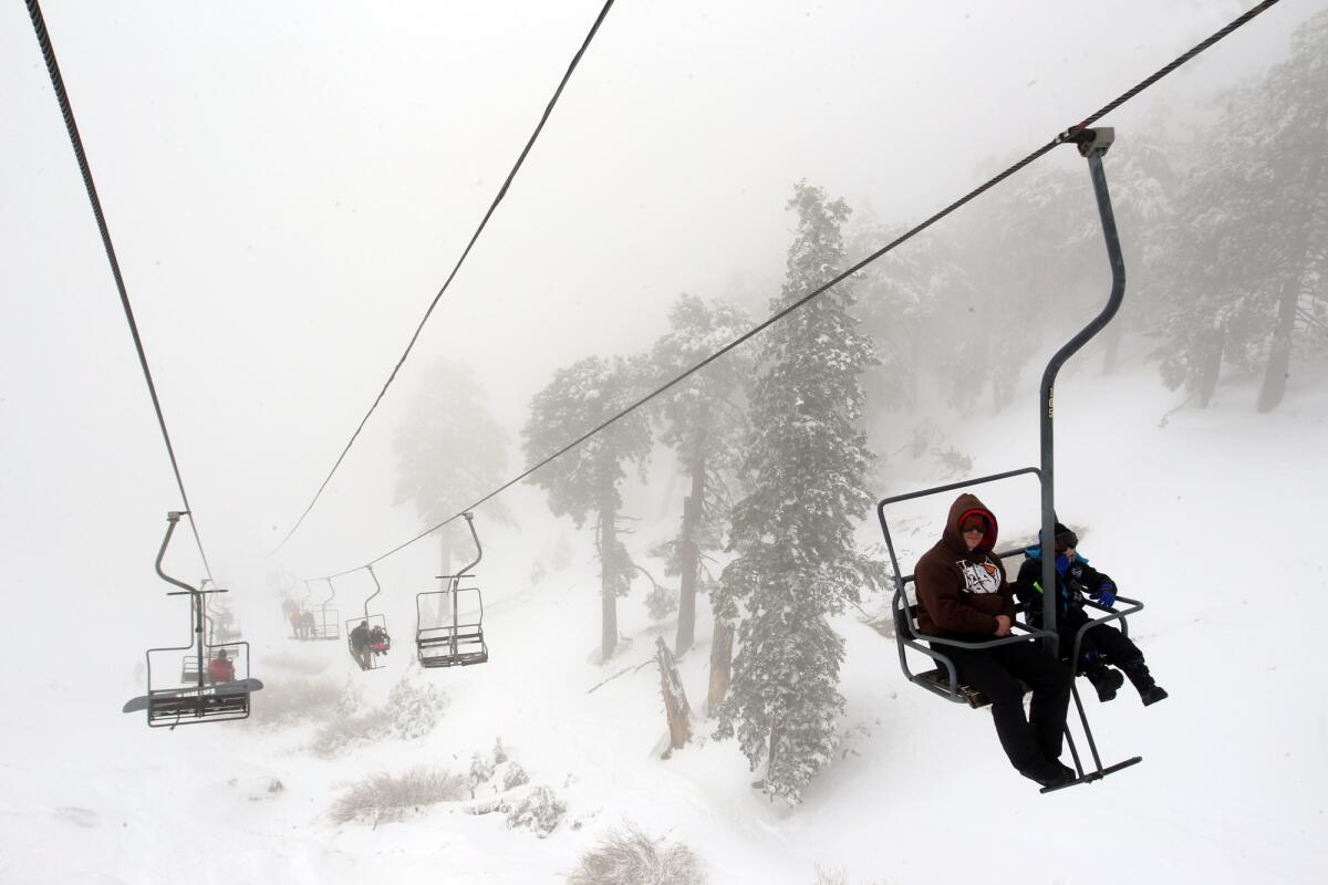 People enjoy the snow-dusted landscape while riding the Mt. Baldy ski lift on Jan. 7.