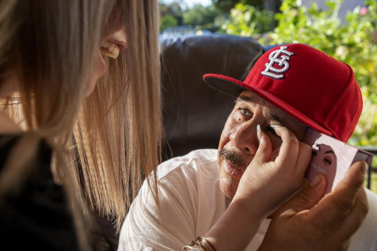  Wendy Rangel puts fake eyelashes on her dad, Genaro Rangel, before filming him on TikTok.