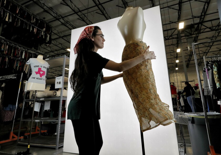 FILE - Samantha Estes prepares garments to be photographed at the ThredUp sorting facility in Phoenix on March 12, 2019. Resale has taken off among some looking to save the planet and spend less on gifts during the most wasteful time of the year _ the December holidays. This year's supply chain delays have provided extra motivation. (AP Photo/Matt York, File)