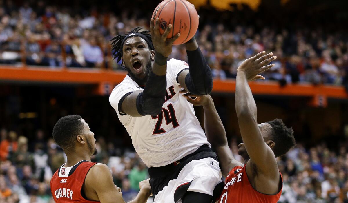 Louisville forward Montrezl Harrell (24) splits the defense of North Carolina State guard Ralston Turner, left, and Abdul-Malik Abu in the first half Friday night in an East Regional game.