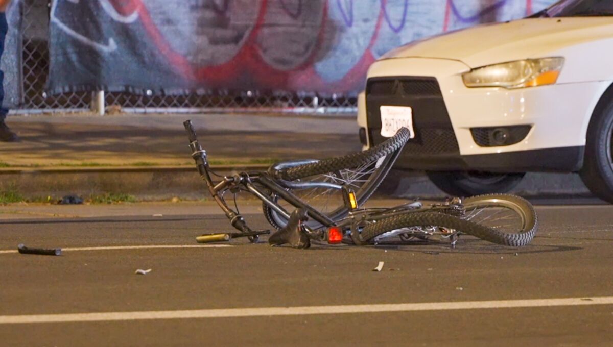 A mangled bicycle in the street surrounded by debris.