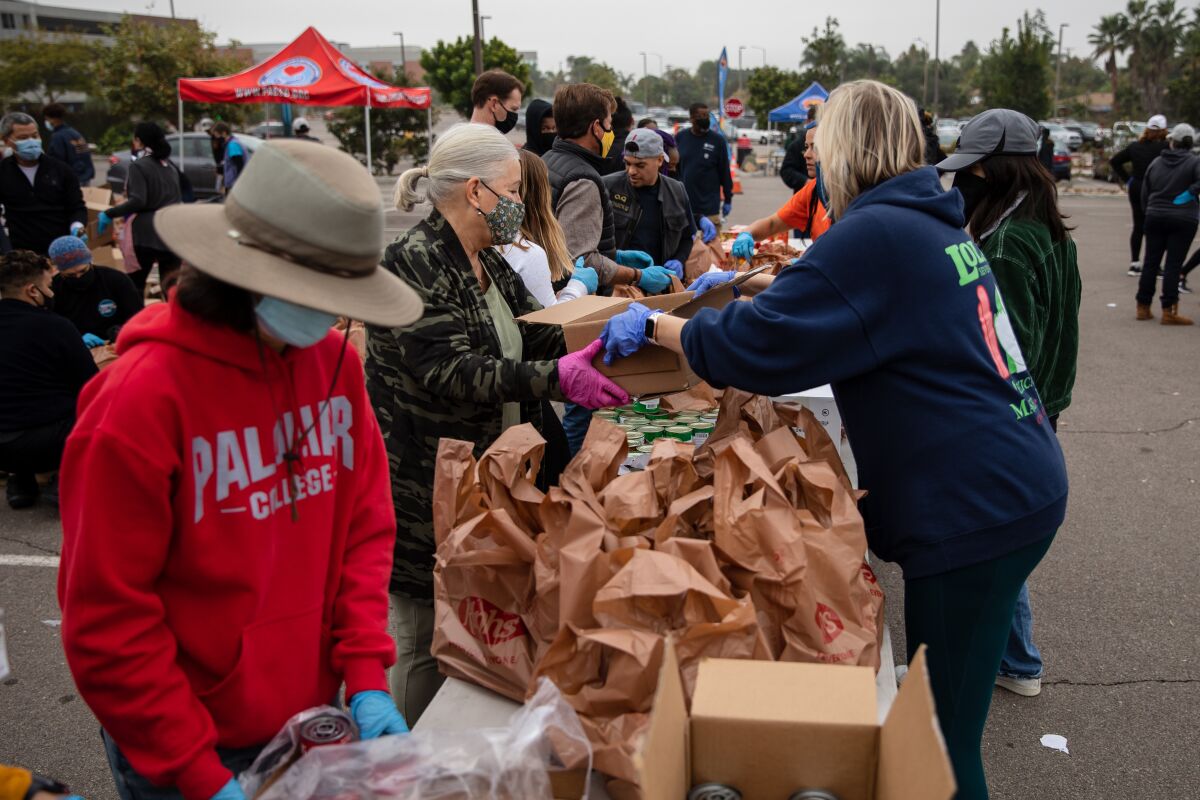 Volunteers pack Thanksgiving bags at a drive-thru, contactless food distribution at Palomar College in San Marcos in 2021. 