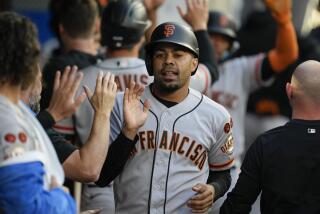 LaMonte Wade Jr. celebrates in the dugout after scoring off of a single hit by designated hitter Wilmer Flores during the third inning of a baseball game against the Los Angeles Angels in Anaheim, Calif., Tuesday, Aug. 8, 2023. Luis Matos also scored. (AP Photo/Ashley Landis)
