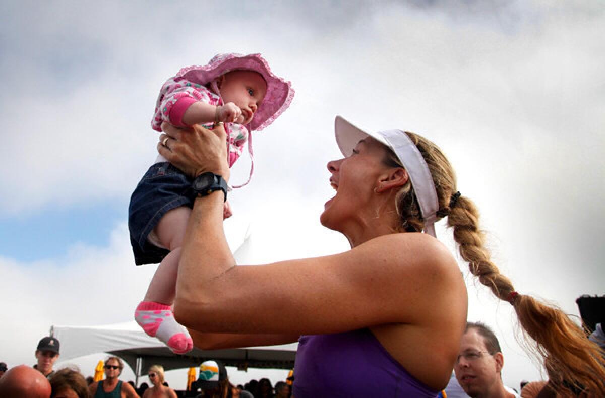 Kerri Walsh Jennings, shown celebrating with son Scout after winning the Manhattan Beach Open in August, is sending an important message for women by going after another Olympic gold medal, beach volleyball veteran Dianne DeNecochea says.