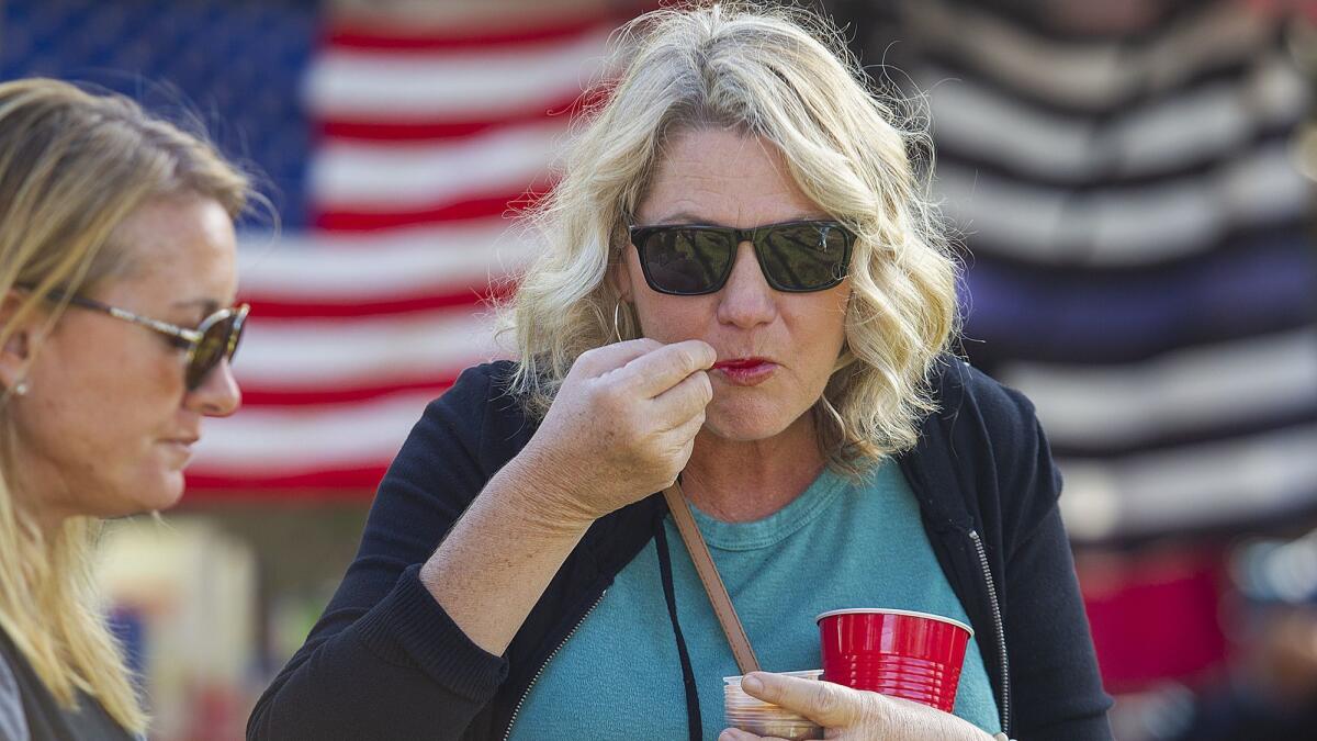 Suzie Smith, left, and Anka Duley eat a sample of chili during the annual Halecrest Park Chili Cook Off in Costa Mesa on Saturday. This year’s cook-off was dedicated to Brad Long, a longtime Costa Mesa city employee who died last November.