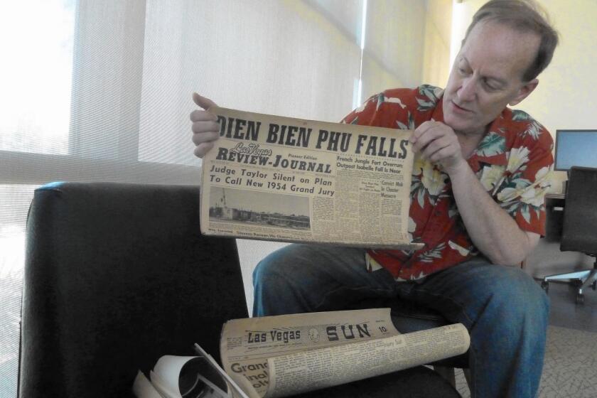 Dennis McBride, head of the Nevada State Museum, shows a newspaper from a 1954 time capsule.