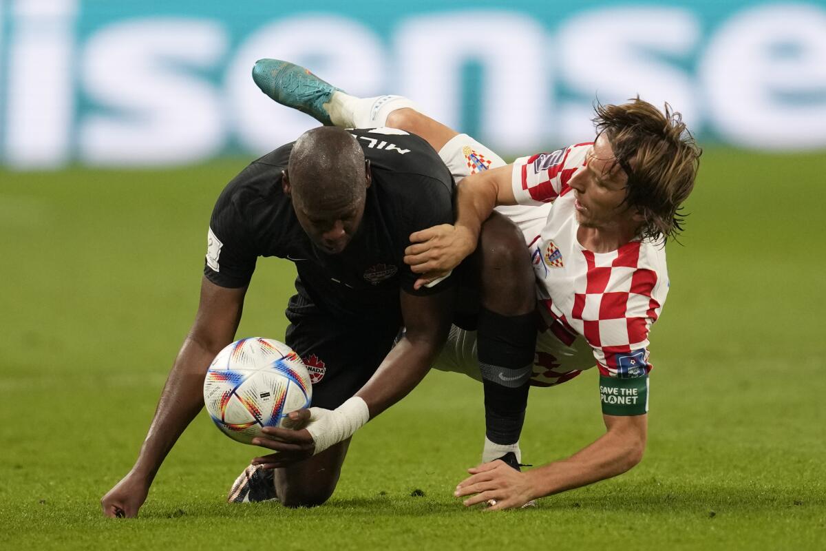 Croatia's Luka Modric, right, gets entangled with Canada's Kamal Miller as they fall to the field.