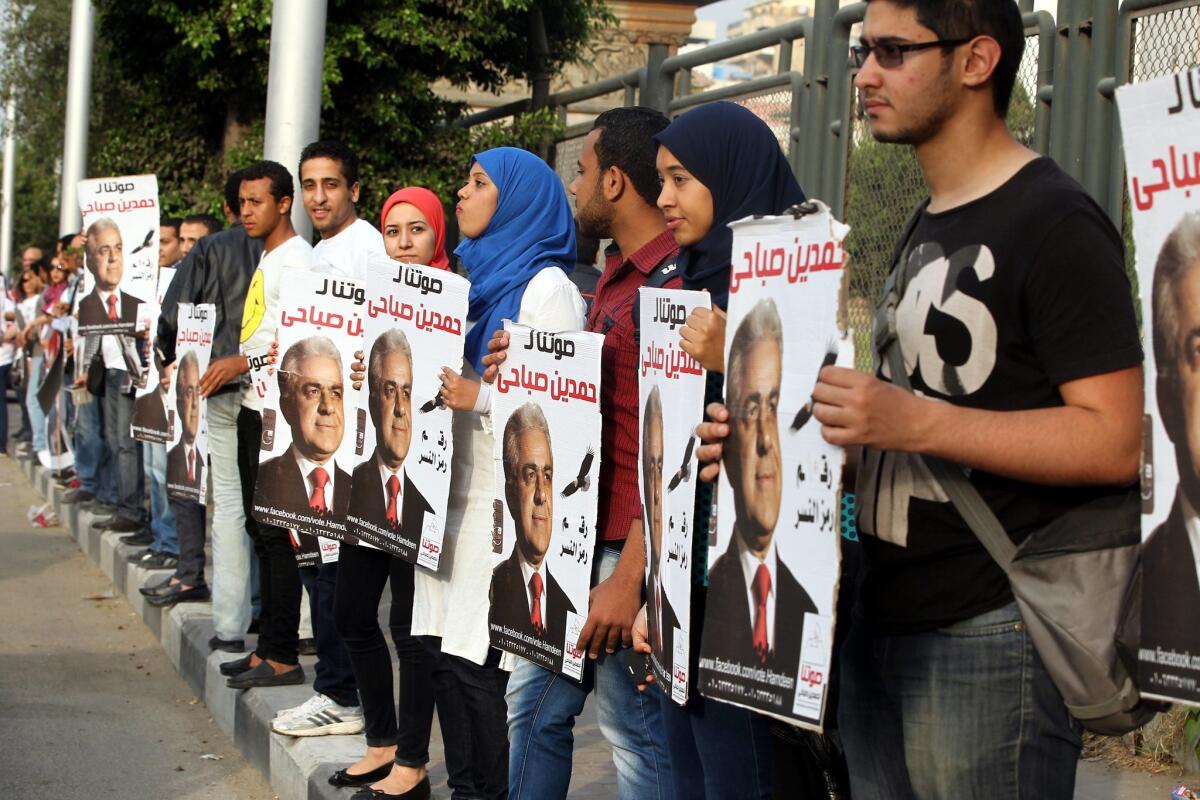 Supporters of Egyptian presidential hopeful Hamdin Sabahi hold up his campaign posters during a demonstration in Cairo.