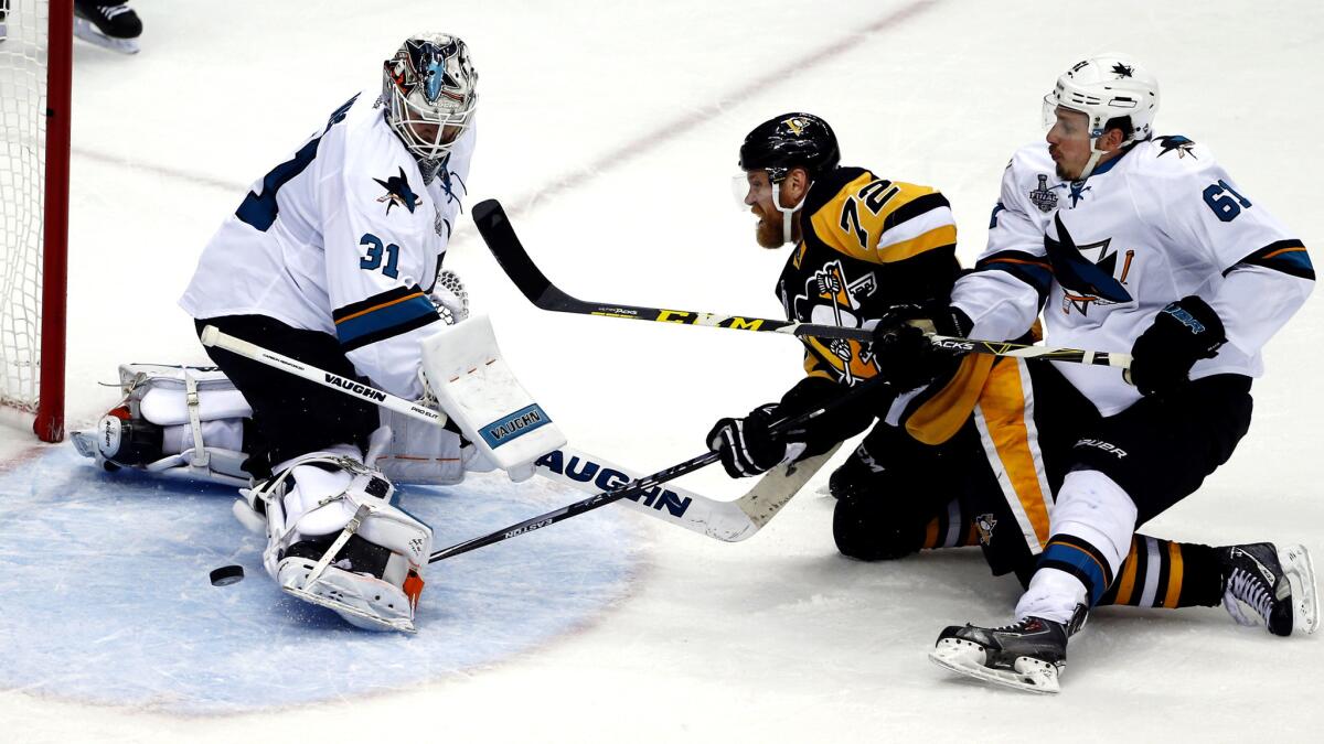 Sharks goalie Martin Jones (31) turns away a shot by Penguins right wing Patric Hornqvist (72), who is defended by Sharks defenseman Justin Braun (61) during the second period of Game 5.
