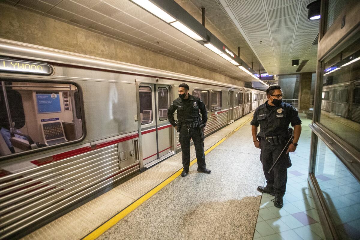 Los oficiales del Departamento de Policía de Los Ángeles, E. Rosales, a la izquierda, y D. Castro, patrullan la Línea Roja del Metro en la estación de metro Hollywood/Highland.