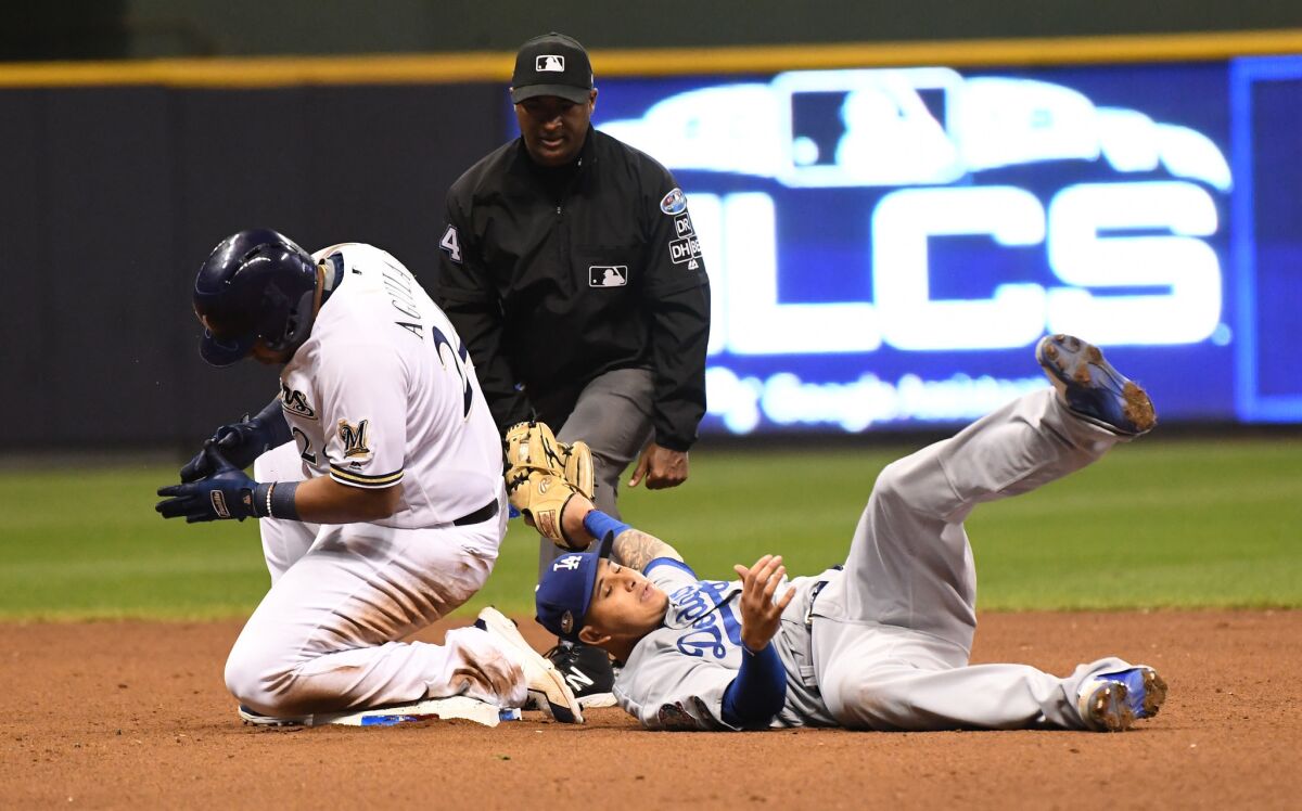 Brewers Jesus Aguilar is safe with a double ahead of a tag by Dodgers shortstop Manny Machado in the 7th inning.