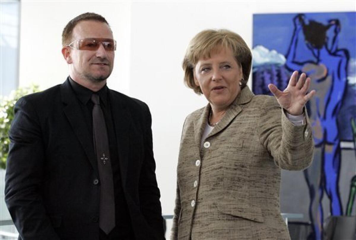 FILE - This is a Tuesday, April 17, 2007 file photo of German Chancellor Angela Merkel, right, and Bono, left, singer of Irish rock band U2, talk during Bono's visit to the Berlin Chancellery . (AP Photo/Fritz Reiss, File)