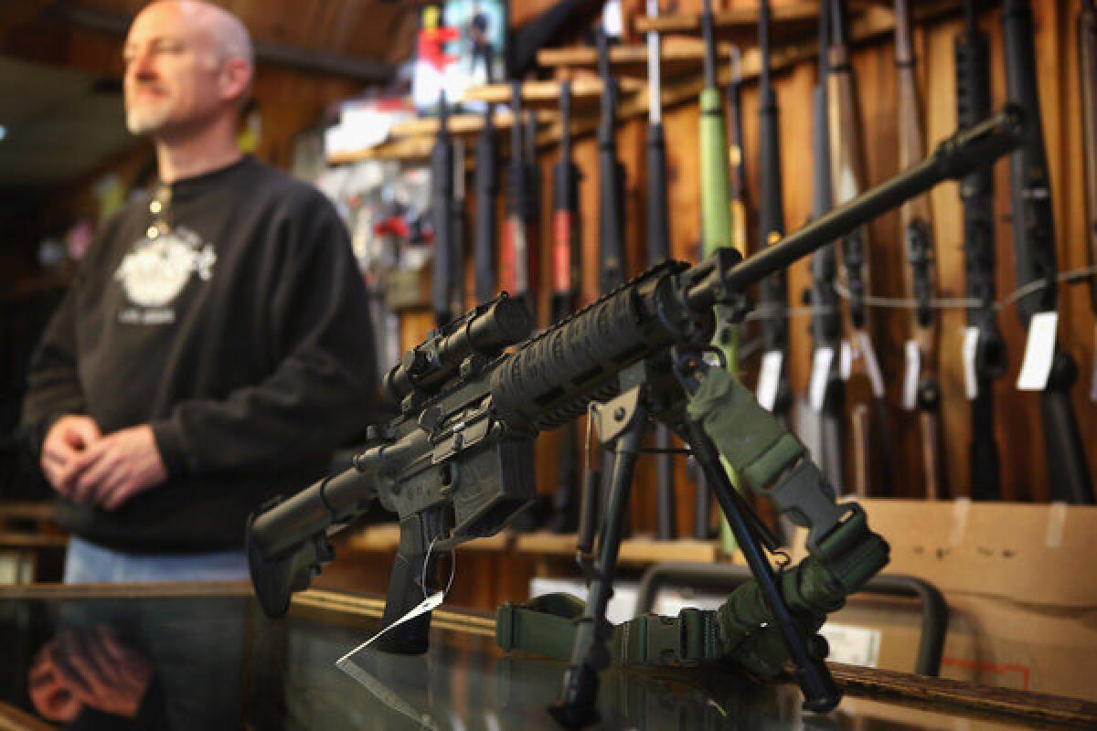 An AR-15 style rifle sits on the counter at Freddie Bear Sports sporting goods store in Illinois. Private equity firm Cerebus said it will cut ties with rifle-maker Bushmaster and its parent company Freedom Group.
