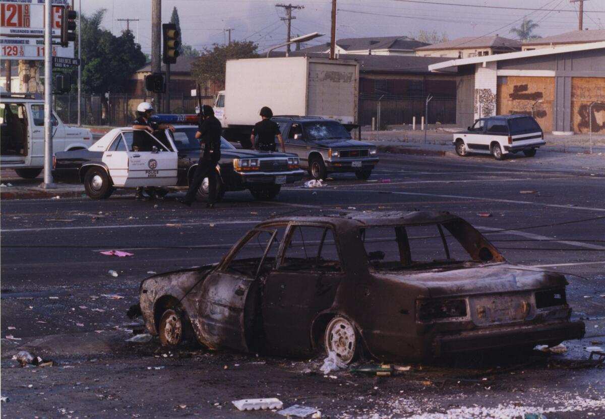 A burned-out car is seen at the intersection of Florence and Normandie on April 29, 1992.