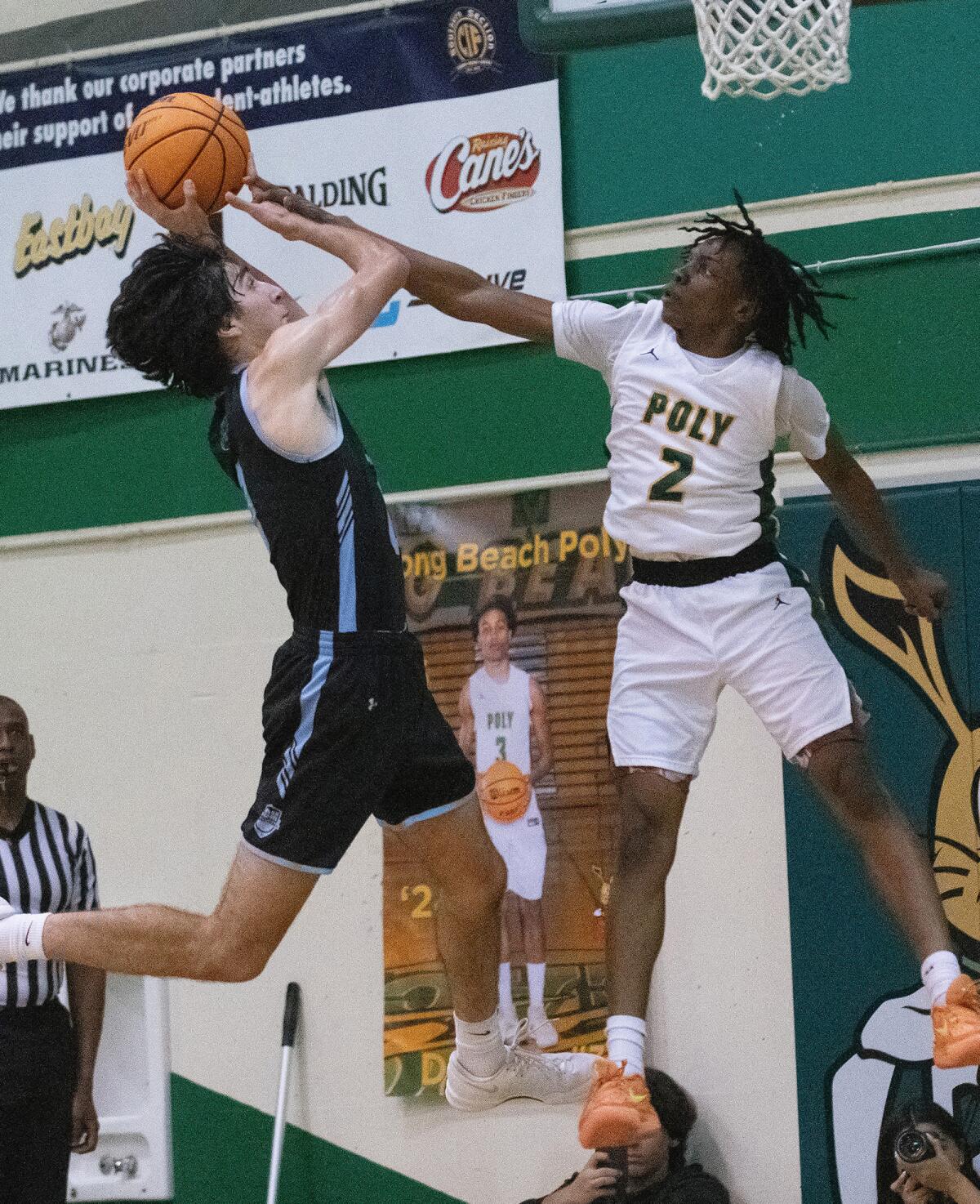 Long Beach Poly sophomore Nana Ofoegbu blocks a shot from Corona del Mar sophomore Luke Mirhashemi during Friday's game.