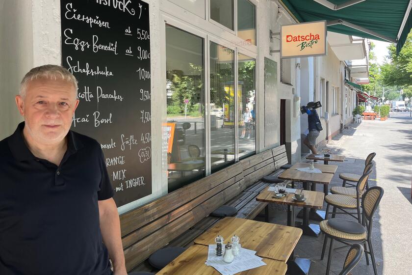 Ilja Kaplan stands outside one of his eight Russian restaurants in Berlin