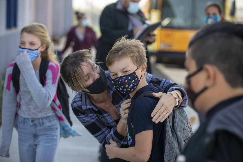 Monika Beranoba hugs her son, Jan, as she drops him off for the first day of in-person learning.