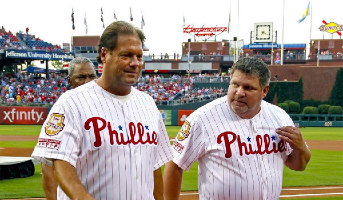 ESPN's John Kruk, right, was taken from the Dodgers press box on a gurney Sunday night before the Dodgers' matchup with the Boston Red Sox because of dehydration, ESPN announced in a statement.