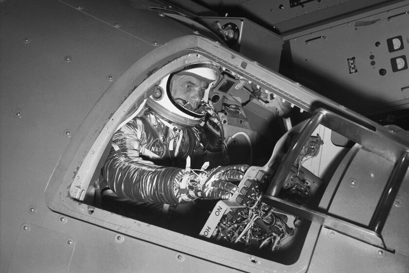 FILE - In this Jan. 11, 1961 file photo, then Marine Lt. Col. John Glenn reaches for controls inside a Mercury capsule procedures trainer as he shows how the first U.S. astronaut will ride through space during a demonstration at the National Aeronautics and Space Administration Research Center in Langley Field, Va. Glenn's birthplace and childhood hometown in Ohio are celebrating what would have been the history-making astronaut and U.S. senator's 100th birthday with a three-day festival from July 16 through July 18, 2021. (AP Photo/File)